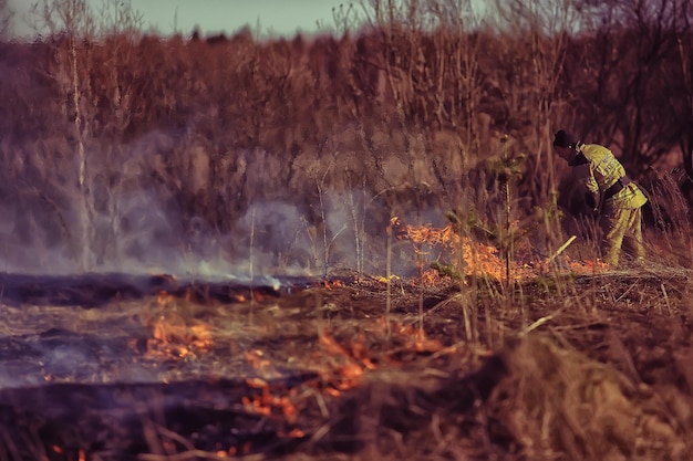 Wologda, Russland - 22. April: Gras brennt, das Feuer läuft, ein Feuerwehrmann löscht einen Waldbrand, 22. April 2019 Wologda, Russland