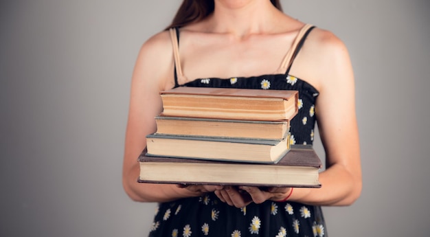 Womam hält einen Stapel Bücher in der Hand