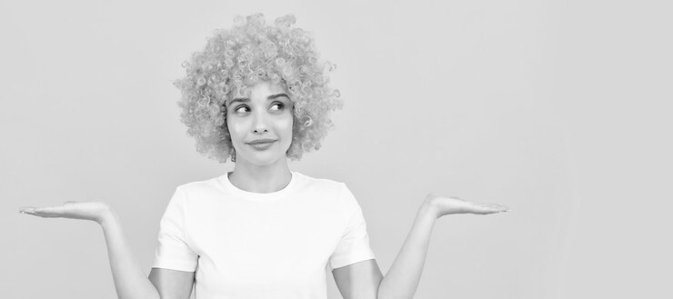 Foto woman isolated face portrait banner with copy space freaky woman in clown wig presenting product express positive emotions funny girl in orange wig