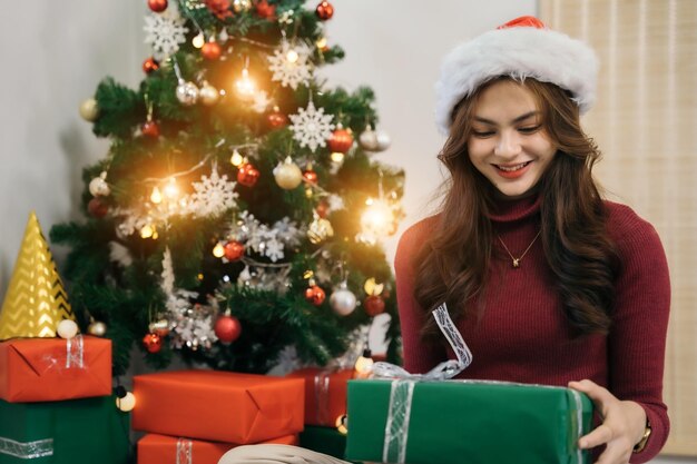 Woman Watch at Christmas Present Portrait of Young female Vorbereitungen für CelebrationHappiness at Home Holiday ConceptDecorating Christmas Tree