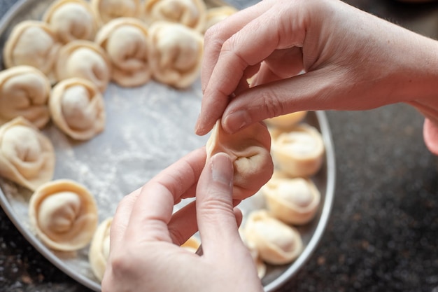 Woman39s Hände geformter Teig mit Fleischfüllung Knödeln Kochen hausgemachte Knödel