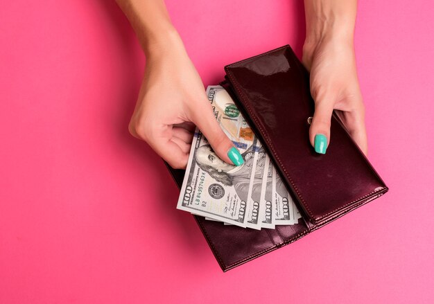 Womans Hand Geld aus Brieftasche Studioaufnahme entfernen