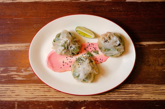 Wontons de verduras de papel de arroz Cocina oriental panasiática en mesa de madera