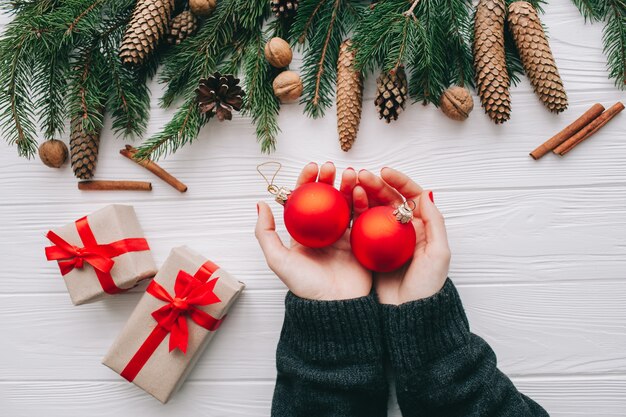 wooman, das Weihnachtsgeschenke auf hölzernem Hintergrund hält