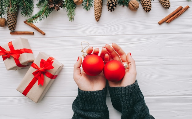 wooman segurando presentes de Natal em fundo de madeira