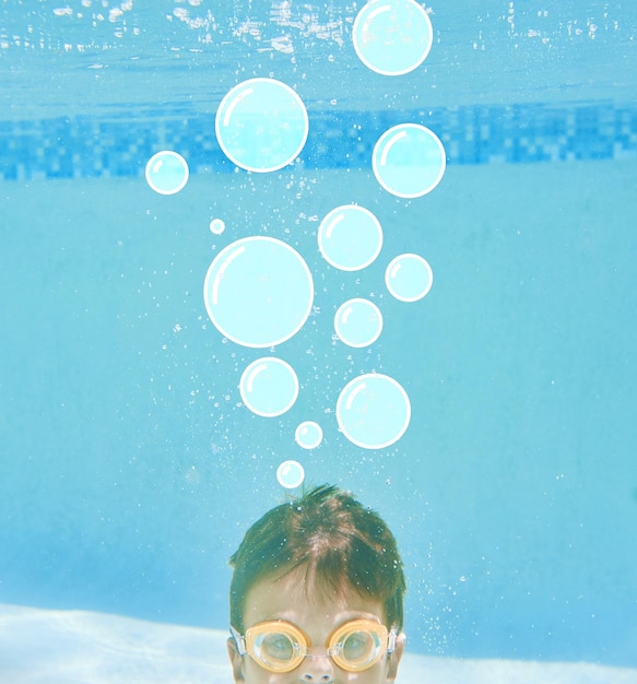 Foto woran denken sie? aufnahme eines kleinen jungen, der unter wasser schwimmt, mit blasen über seinem kopf