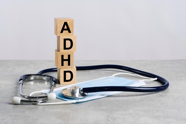 Word adhd está hecho de cubos de madera con estetoscopio y máscara de medicina concepto médico de tratamiento de prevención y efectos secundarios adhd abreviatura de síndrome de déficit de atención con hiperactividad