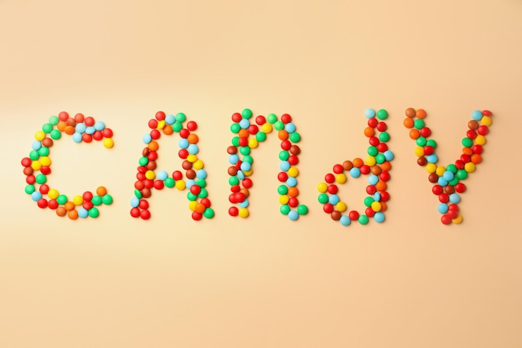 Foto word candy hecho de sabrosos dulces sobre fondo beige plano