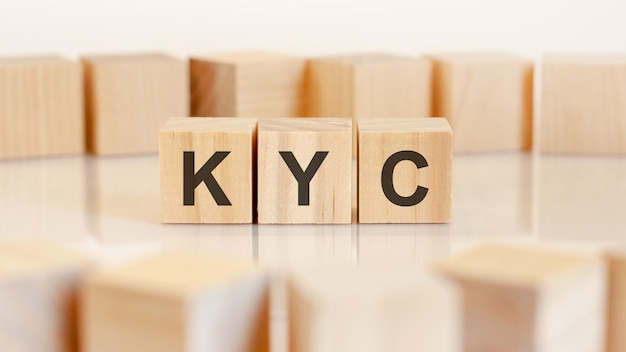 Word KYC está escrito en cubos de madera parados en fila. alrededor de los bloques sobre un fondo claro. se puede utilizar para negocios y conceptos financieros. KYC abreviatura de conoce a tu cliente