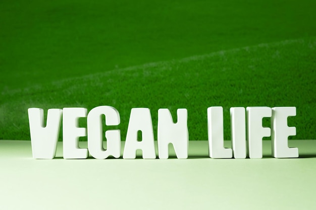 Word Vegan life feito de letras brancas de concreto sobre fundo verde