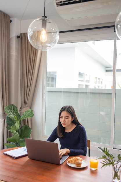 Work from home concept: una trabajadora independiente que parece feliz mientras trabaja en línea en su propio espacio durante la pandemia de Covid 19.