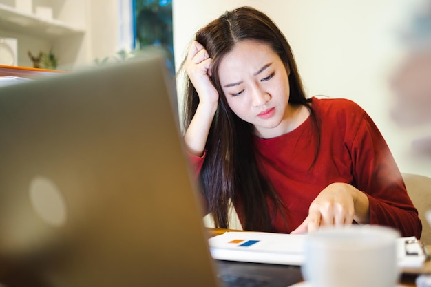 Workaholic-Leute Asiaten gestresst Elegante Bürodame überprüft Berichte während der Überstunden zu Hause