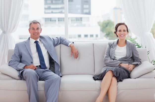 Workmates, die zusammen sitzen auf Sofa aufwerfen