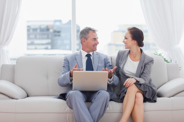 Workmates, die zusammenarbeiten, sitzend auf Sofa