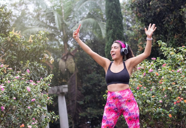 Workout und Chill Latin Woman Videoanrufe Freunde nach Outdoor-Übungen an einem regnerischen Tag