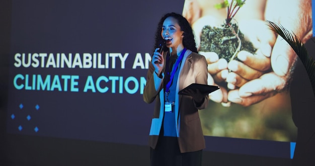 Workshop de apresentação e mulher num palco para a exposição comercial e seminário sobre alterações climáticas Audiência de oradores públicos e pessoa com tablet num evento para a sustentabilidade ambiental e a agricultura