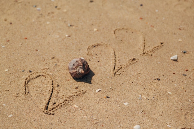 Wort 2022 geschrieben auf den Sand eines Strandes. Text des neuen Jahres 2022 am Meeresstrand. Urlaub entspannen