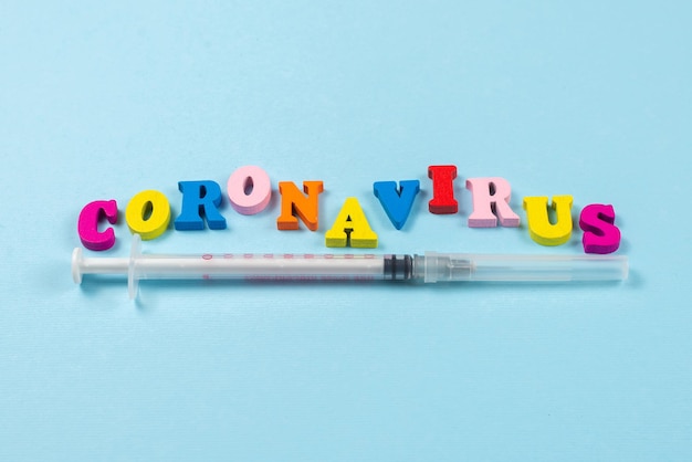 Wort Coronavirus auf blauem Hintergrund geschrieben. Ansicht von oben. Platz kopieren