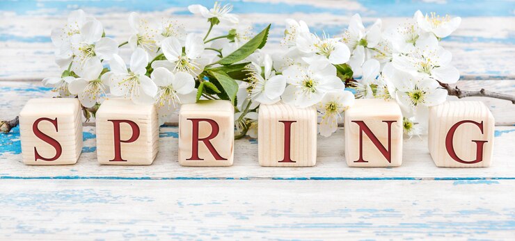 Foto wort frühling geschrieben von holzwürfeln mit buchstaben und kirschblüten auf dem holztisch