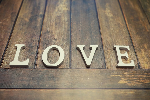 Wort Liebe aus Holzbuchstaben auf Holzhintergrund