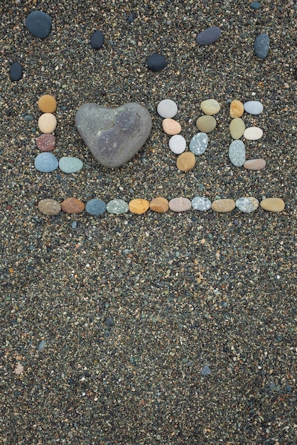 Wort Liebe aus Steinen am Sandstrand