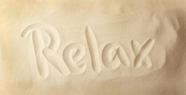 Foto wort „relax“ auf sand geschrieben
