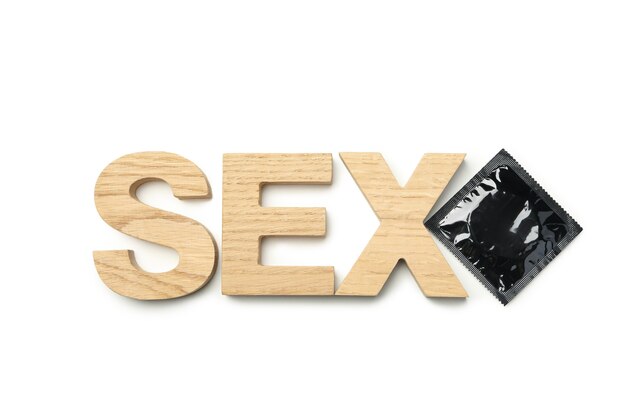 Wort Sex gemacht aus Holzbuchstaben und Kondom auf weißem Hintergrund