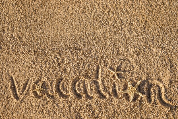 Wort Urlaub am Strand in den Sand geschrieben