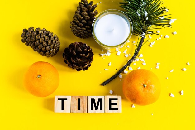 Wort ZEIT auf Holzklötzen auf gelbem Hintergrund mit Mandarine. Gesundes Ernährungskonzept