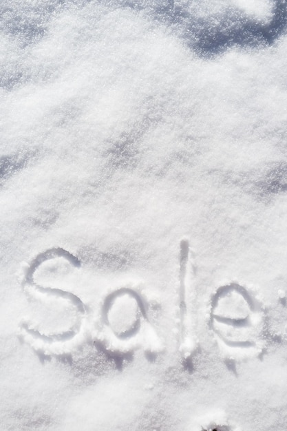 Wortverkauf an einem sonnigen Tag vertikal in den Schnee geschrieben