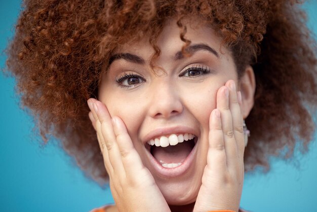 Wow Überraschung und Porträt einer glücklichen Frau in einem Studio mit Mockup-Platz zum Verkauf oder Rabatt Glücksschrei und weibliches Modell mit aufgeregtem und schockiertem Gesichtsausdruck vor blauem Hintergrund