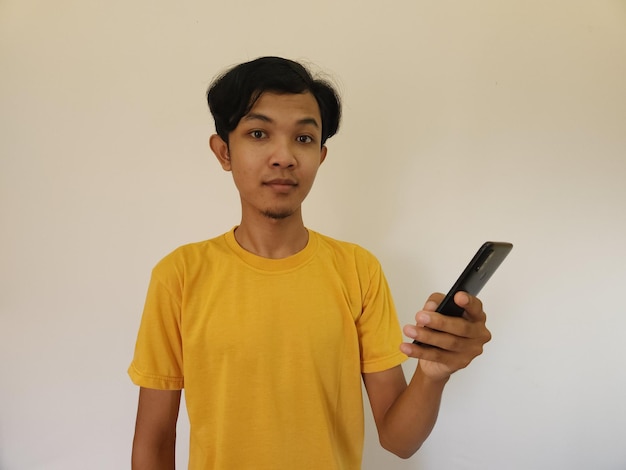 Wow y cara sorpresa hombre asiático usa teléfono inteligente con espacio de copia de anuncio