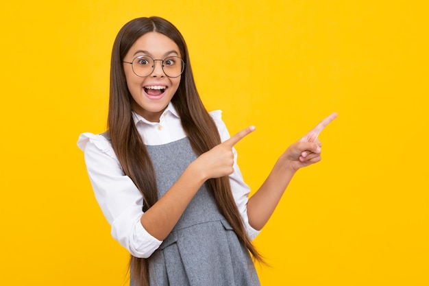 Wow, es increíble Niño adolescente conmocionado señalando a un lado en el espacio de la copia Niña adolescente señalando