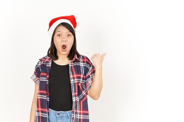 Wow-Gesicht und Zeigeprodukt auf der rechten Seite asiatische Frau mit rotem kariertem Hemd und Weihnachtsmütze