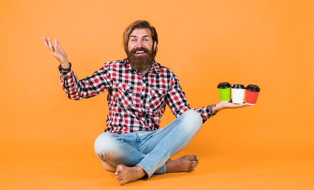 Wow Halten Sie eine Papptasse Kaffee oder Tee. Lifestyle-Konzept. Hübscher Hipster-Mann mit einer Tasse Kaffee zum Mitnehmen. Er macht eine Kaffeepause. Hübscher reifer Mann, der aus einer Tasse trinkt