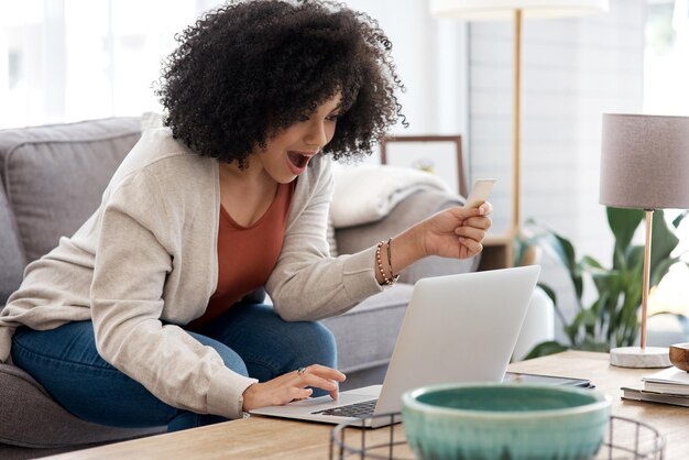 Foto wow laptop e uma mulher com cartão de crédito para venda de compras online e desconto de produtos surpresa feliz e uma jovem com choque sobre o pagamento do serviço de comércio eletrônico e serviços bancários em um computador em casa