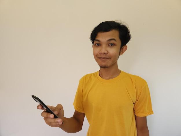 Wow und Überraschungsgesicht asiatischer Mann benutzt Smartphone mit Kopierfläche für Werbung