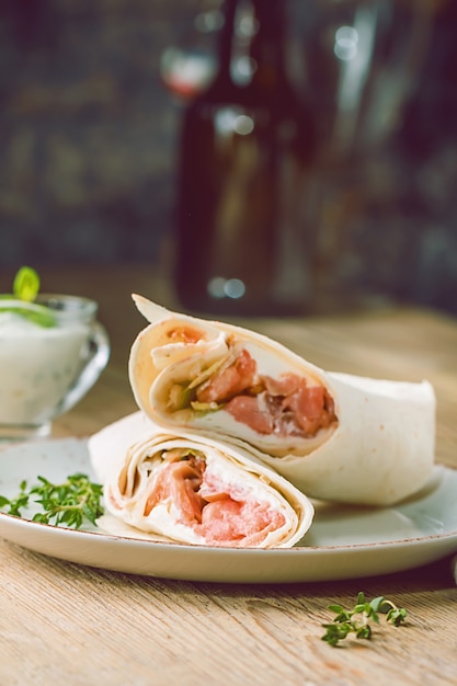 Wrap de tortilha fresca com legumes e salmão no prato