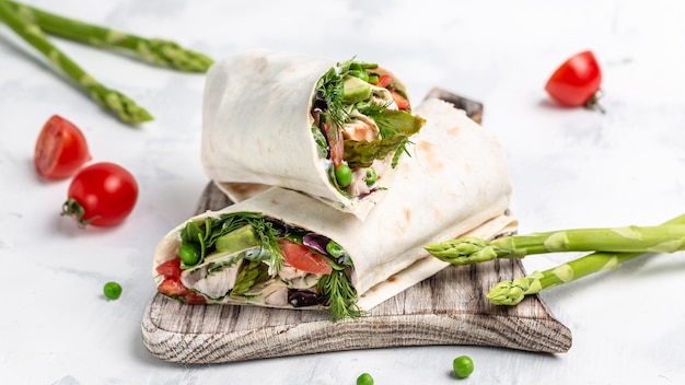 Wrap de tortilla com carne de frango e vegetais aspargos, abacate, tomate, ervilha, queijo e tártaro