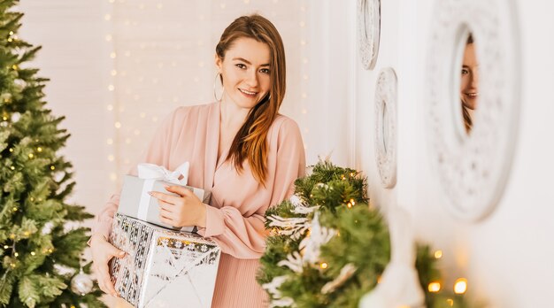 Wünschen Ihnen ein frohes Weihnachtsfest. Mädchen mit einem Geschenk präsentiert. Frohes Gefühl zum neuen Jahr.