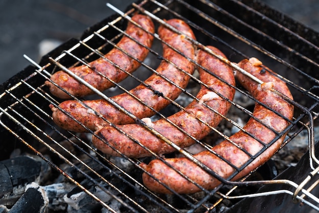 Würstchen auf dem Grill im Grill im Freien beim Picknick kochen