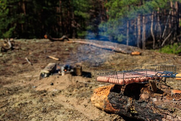 Würstchen im barbecue-grill am lagerfeuer bereit zum grillen