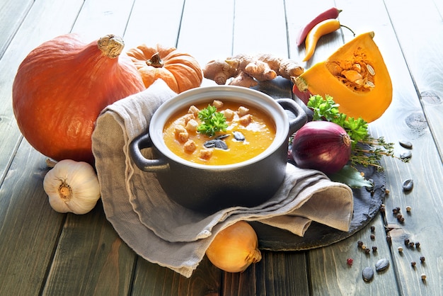 Foto würzige kürbiscremesuppe mit karotten- und paprikapfeffer auf holz