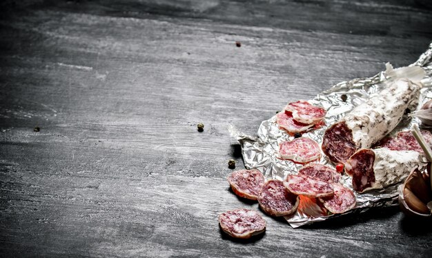 Würzige Salami mit Gewürzen auf der Folie.