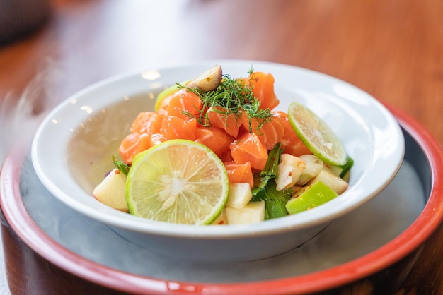 Würziger geschnittener Lachs mit Obstsalat in weißer Keramikschale