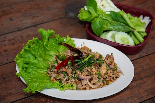 Würziger Hackfleischsalat mit Gemüse auf dem Holztisch