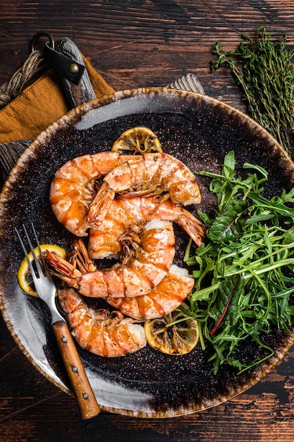 Würziger Knoblauch Riesengarnelen in Platte mit Salat Holzhintergrund Ansicht von oben