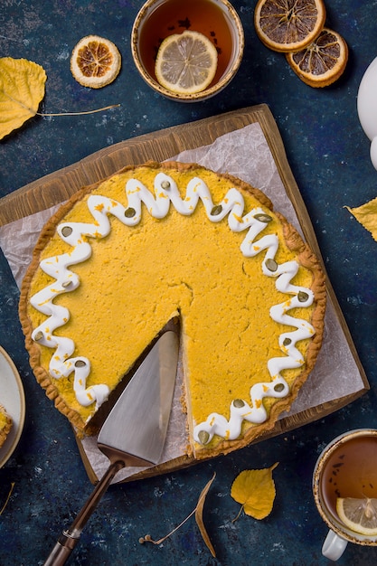 Würziger köstlicher runder kürbiskuchen verziert mit weißer creme und kürbiskernen