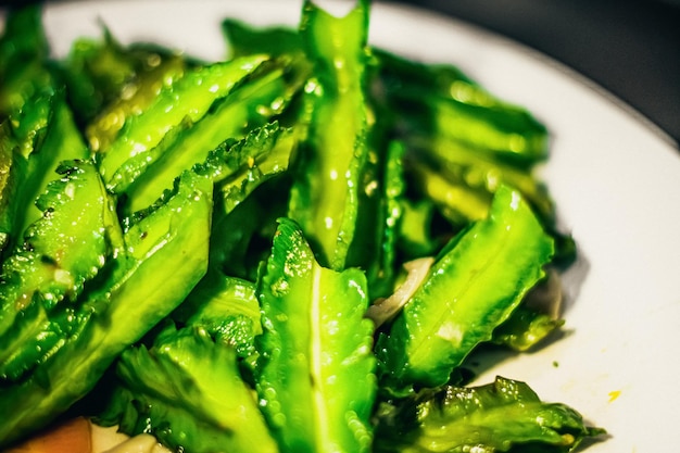 Würziges asiatisches oder koreanisches veganes Gemüsesalat-Essen mit frisch gebratenem Drachengras Foto als Designhintergrund für Restaurant Street Meal gesundes ungesundes Gericht Konzept Hellgrüne Tonfarbe