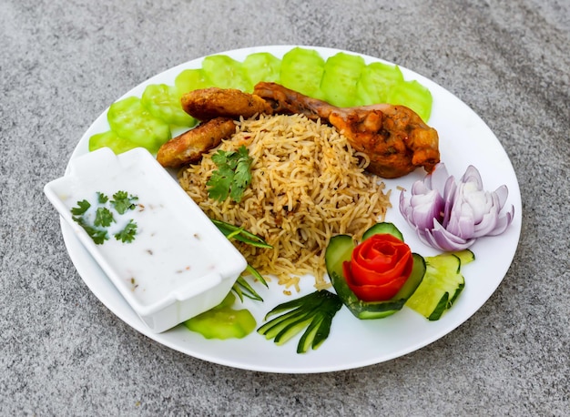 Würziges Hähnchen-Yakhni-Pulao mit Shami-Kabab-Raita und Salat, serviert in einer Schüssel isoliert auf dem Hintergrund, Draufsicht auf indische Gewürze und pakistanisches Essen